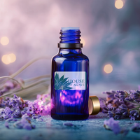 Blue bottle with 'House of Agave' label surrounded by lavender flowers on a blurred background at ouse of Agave.