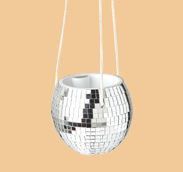 Silver disco ball hanging from a white background